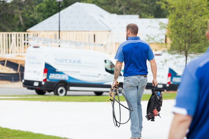 Technician carrying AC repair equipment out to his van